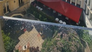 Un edificio moderno con fachada de vidrio y un toldo rojo sobre una zona de estar.
