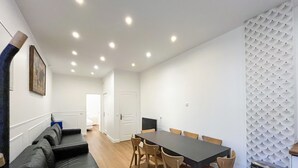 A dining area with a long table, chairs, and a sofa.
