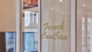 Una puerta de cristal con el texto 'French CanCan' escrito en ella.