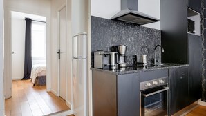 Eine moderne Küche mit Einbauofen, Kaffeemaschine und Dunstabzugshaube.