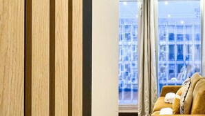A modern interior with a wooden door, a sofa, and a large window with curtains. - Urban Flat 129 - Art Love Champs-Elys&eacute;es (París)