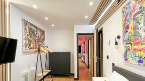 A modern hotel room with a flat-screen TV, a wardrobe, and a large abstract painting on the wall. - Urban Flat 129 - Art Love Champs-Elys&eacute;es (París)