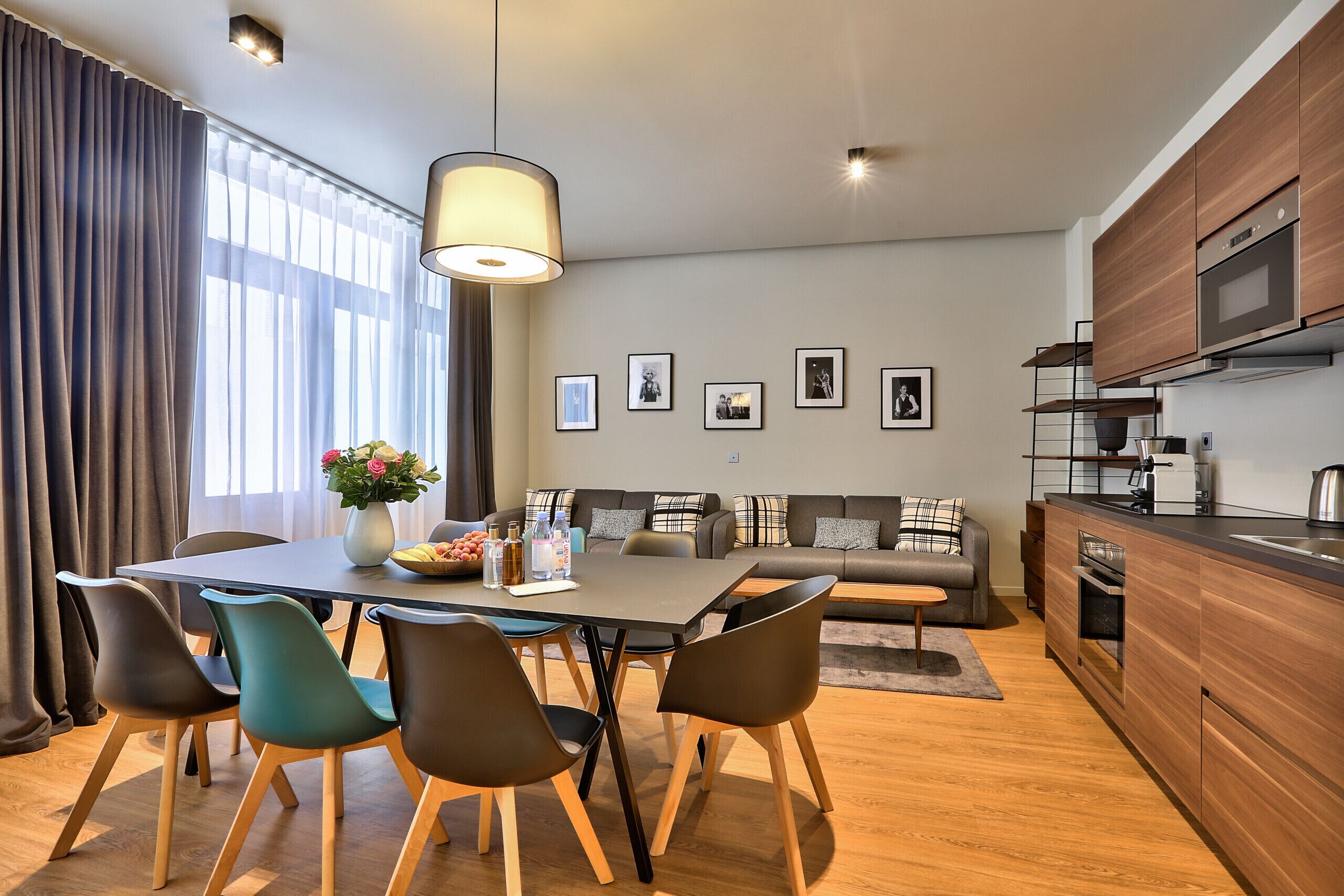 A modern kitchen with wooden cabinets, a built-in oven, and a microwave.