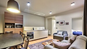 Una sala moderna con comedor, cocina y un conjunto de sofás.