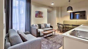 Una sala de estar moderna con un sofá, una mesa de centro y un comedor con sillas y una mesa.