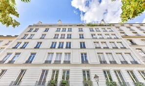 Un edificio a più piani con una facciata simmetrica, ampie finestre e balconi.
