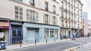 Calle con edificios, un escaparate azul y un letrero que dice 'LA VIGERONNE'.
