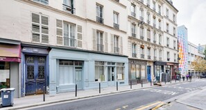 A street view with buildings, a blue storefront, and a sign for 'LA VIGERONNE'.
