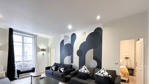 A modern living room with a sofa set, a coffee table, and a large abstract wall art piece. - 64 - Urban Luxury Flat near Champs-Elysées (París)