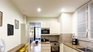A compact kitchen with a microwave, coffee maker, and a dishwasher. - UrbanFlat 64 - Urban Luxury Flat near Champs-Elysées (París)