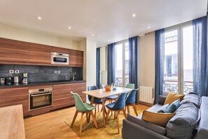 Enjoy a comfortable living space with a kitchen area, sofa, and coffee table, offering a view of the outside balcony.