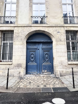 Traditional building with a striking entrance featuring a dark blue door and ornate metalwork.