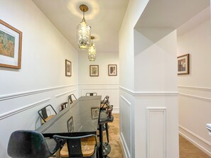 A conference room with a long table, chairs, and framed pictures on the walls.