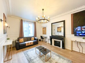A living room with a fireplace, a sofa, a coffee table, and a television.