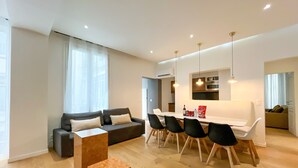 A modern living room with a sofa, dining table, chairs, and a coffee table. - Urban Flat 69 - Beautiful Parisian Apartment in Center of Paris (París)