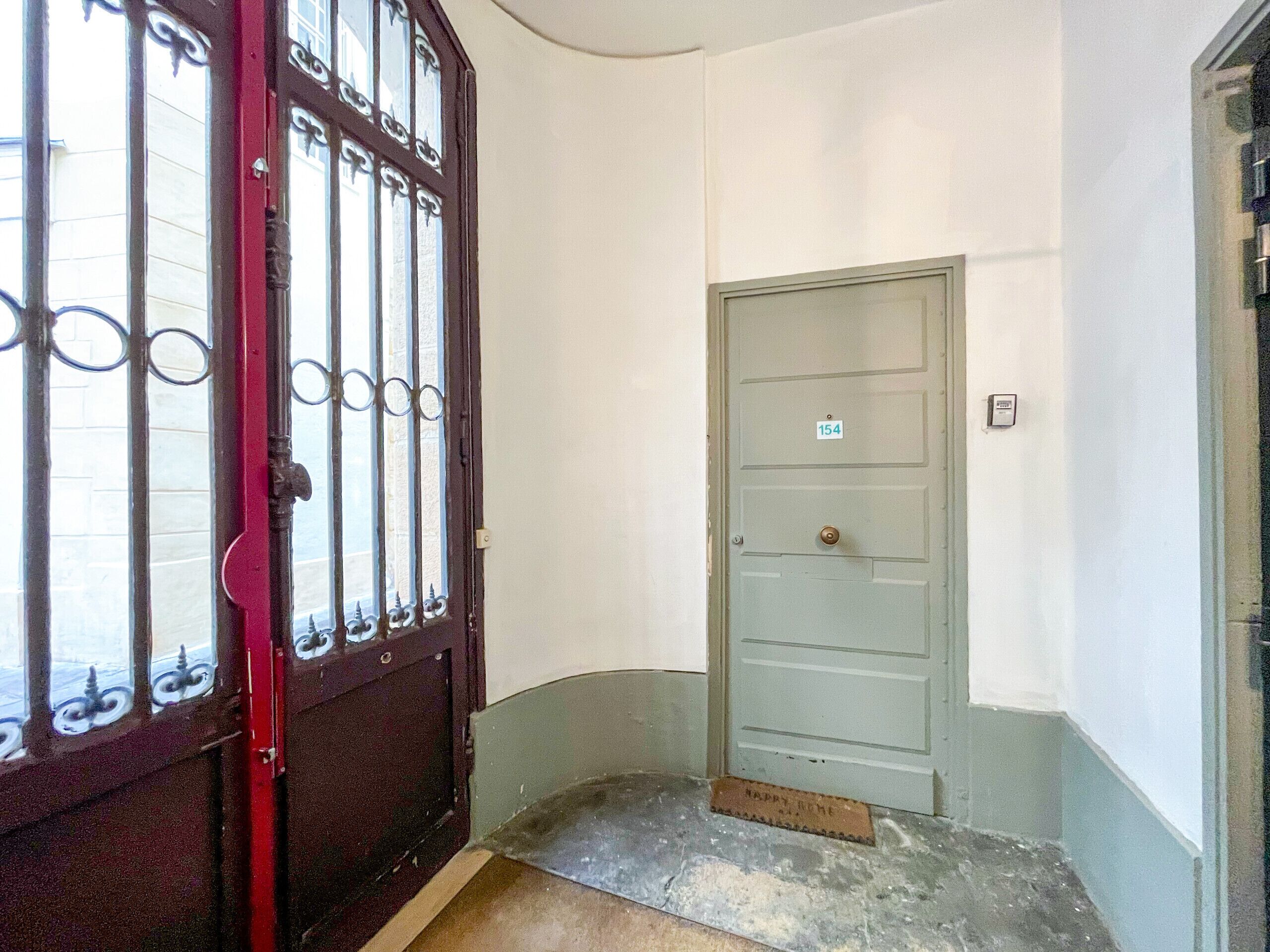 A narrow hallway with a closed door marked with the number 154.