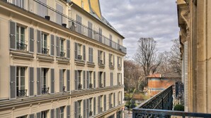 A multi-story building with balconies, large windows, and a street view.
