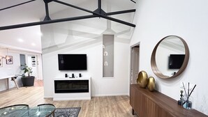 A modern living room with a glass dining table, a wooden cabinet, and a large mirror. - Urban Flat 161 - Sublime 4BDR Luxury Flat in Paris (París)