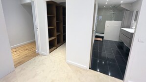 A room with a wooden floor, a white wall, and a black tiled floor. - Urban Flat 166 - 4BDR Luxury Apartment in Center of Paris (París)