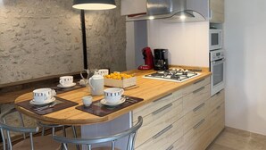 Una cucina moderna con isola centrale, piano cottura a gas, macchina per caffè e forno a microonde.