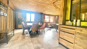 A wooden interior with a dining area, a kitchen counter, and a large window. - Le P'tit Curieux - Rupt-sur-moselle (Rupt-sur-Moselle)