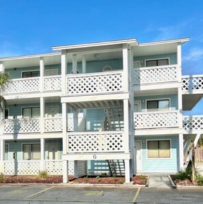 A multi-story hotel with balconies and a parking area. - Ocean view, great location, near Pier Park (Panama City Beach)