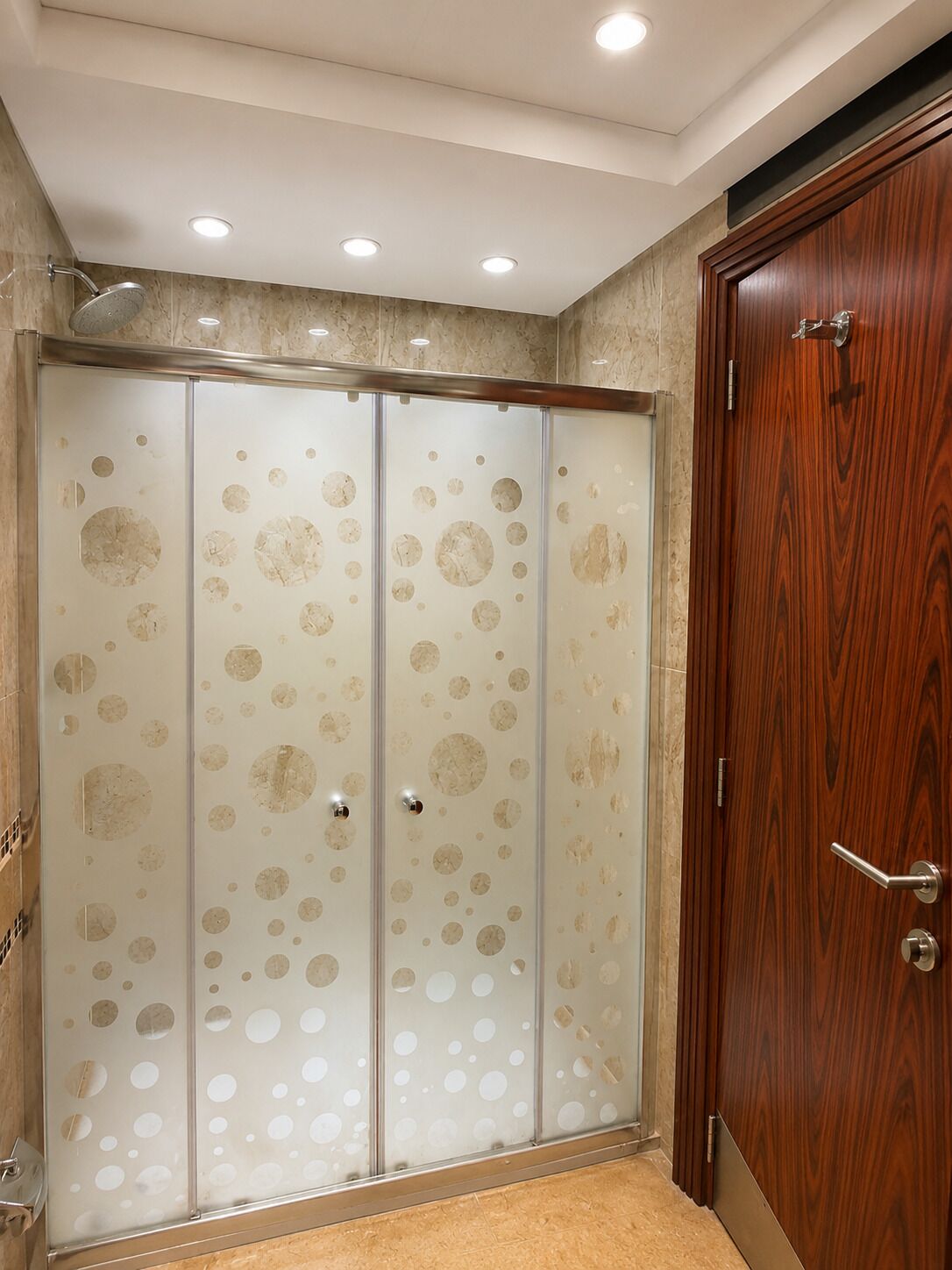 A room with a sliding glass door with circular patterns, a wooden door, and a shower area.