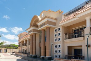 Un hotel de varios pisos con un estilo arquitectónico clásico, que presenta columnas y balcones.