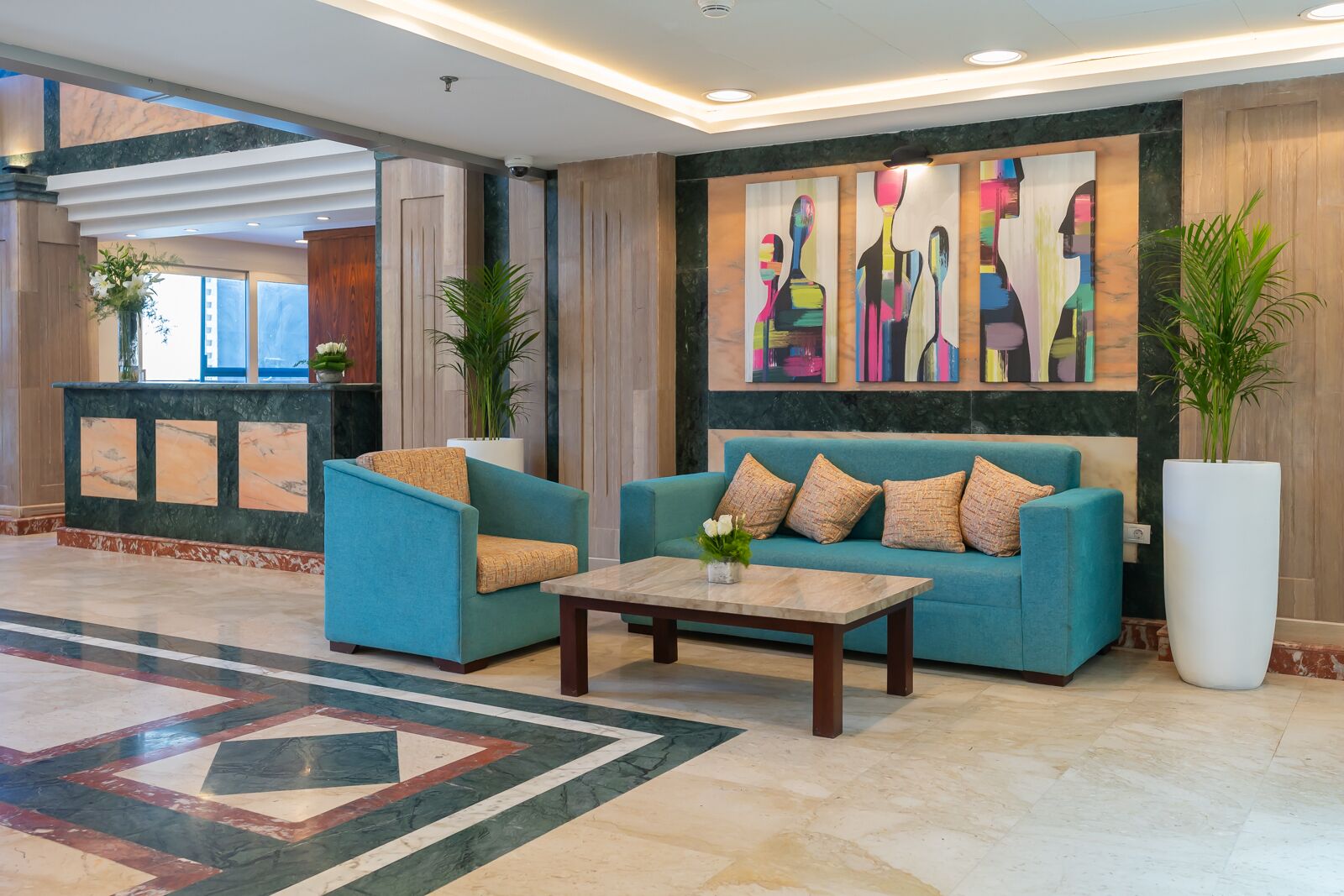 A lobby with two sofas, a coffee table, and a large abstract painting on the wall.
