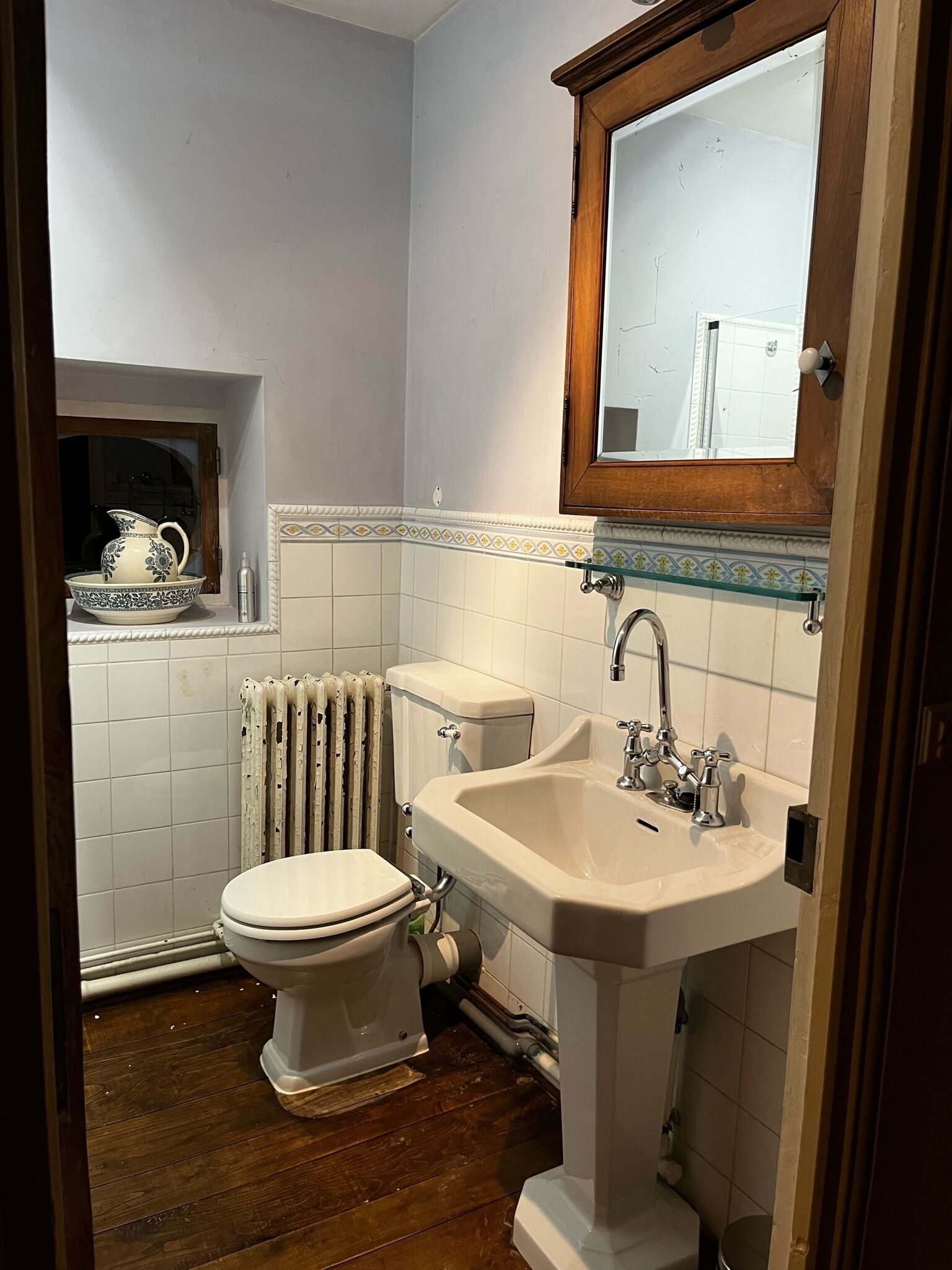 Un baño con inodoro, lavabo y radiador.