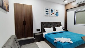 A modern bedroom with a bed, a wardrobe, and a window. - Hotel Fortune (Surat)