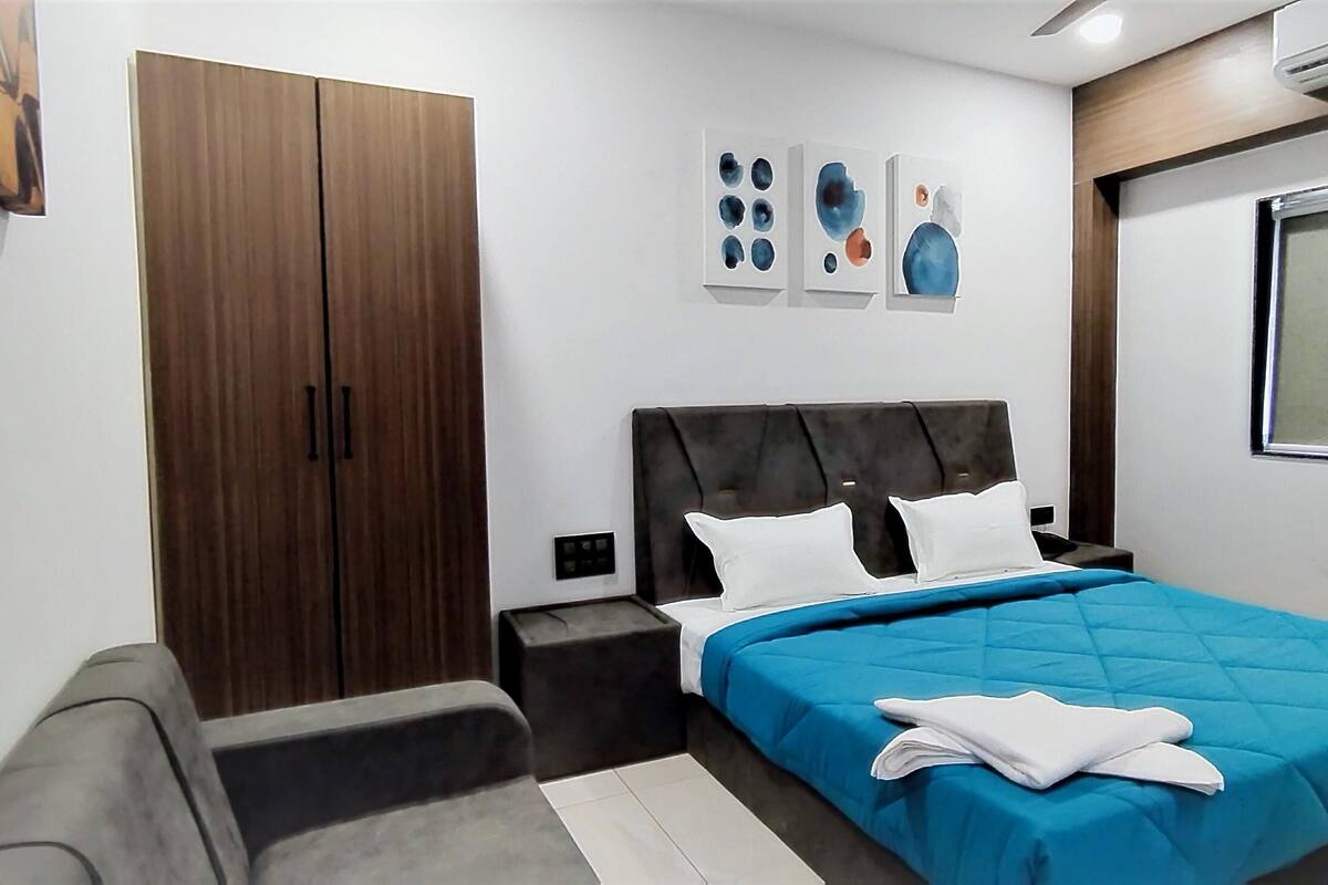 Un dormitorio moderno con cama, armario y ventana.