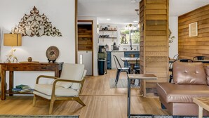 A modern living room with a wooden floor, a sofa, a chair, a coffee table, and a decorative wall piece. - Cozy Sugar Ski - 4 Ensuites, Extremely close to Slopes, Tubing, and Ice Skating! (Sugar Mountain)