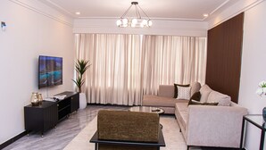 Un salon moderne avec un canapé, une table basse, un téléviseur et une plante décorative.