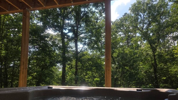 A hot tub with a view of a forest.