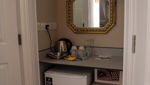 Une petite cuisine équipée d’un réfrigérateur, d’une machine à café et d’un four à micro-ondes.