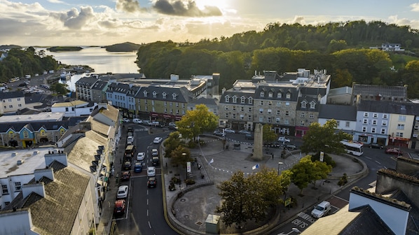 A coastal town with a central roundabout, historic buildings, and a view of the sea.