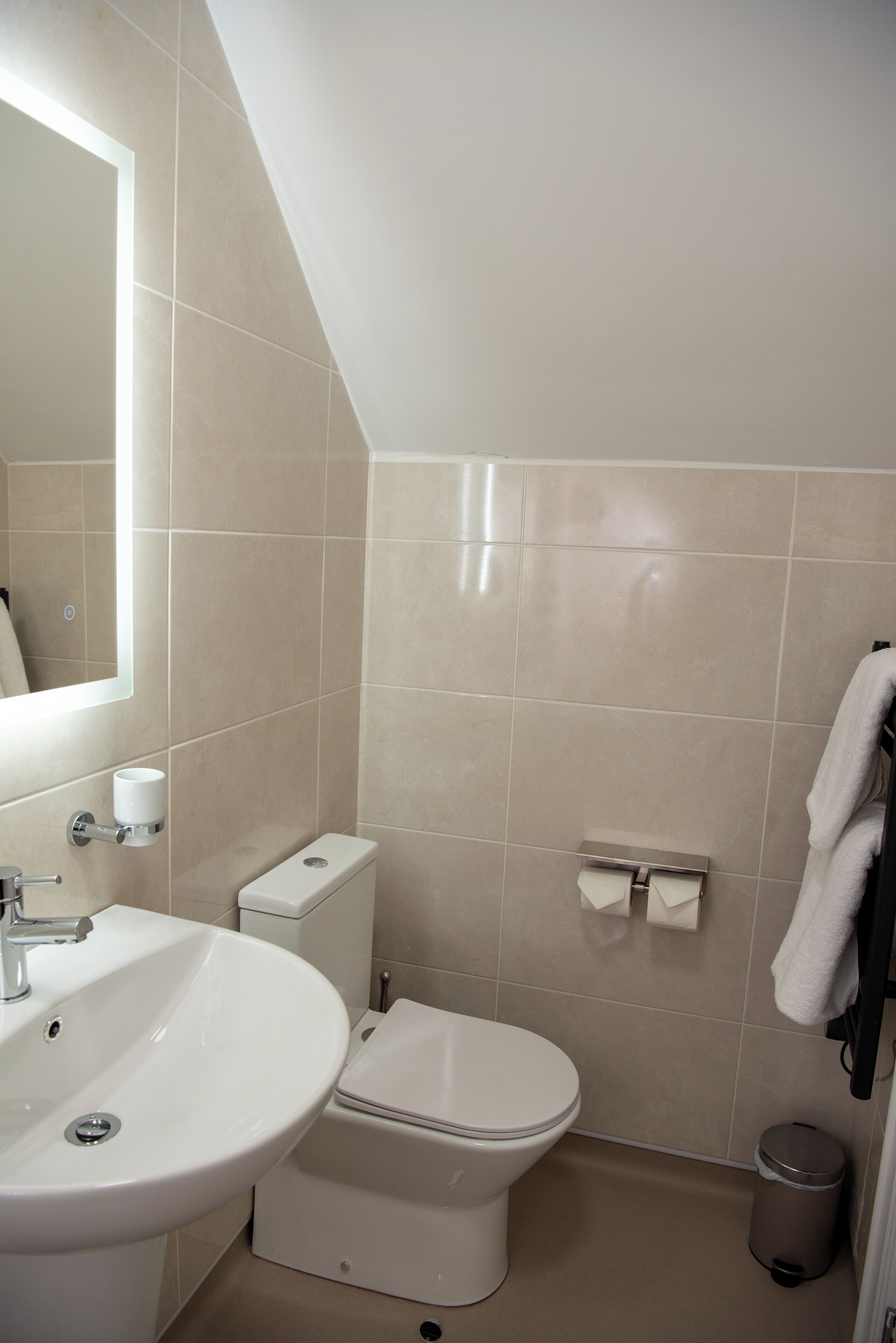 A modern bathroom with a sink, toilet, and mirror.