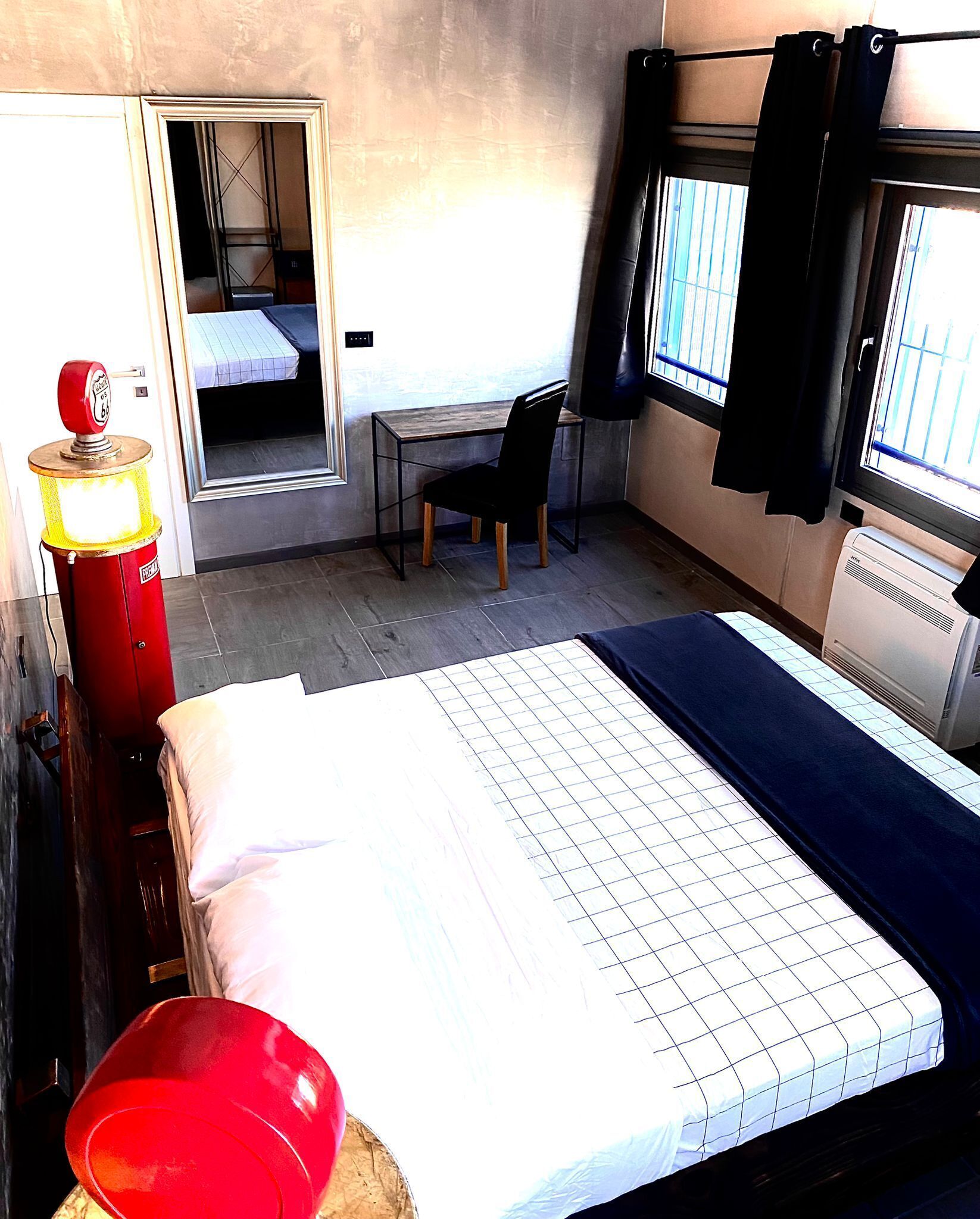 A compact hotel room with a bed, a desk, and a chair.