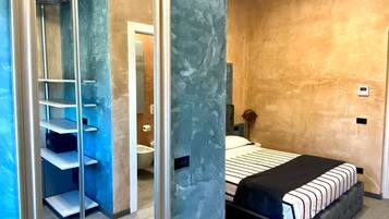 A bedroom with a bed, a large mirror, and a wardrobe with shelves.