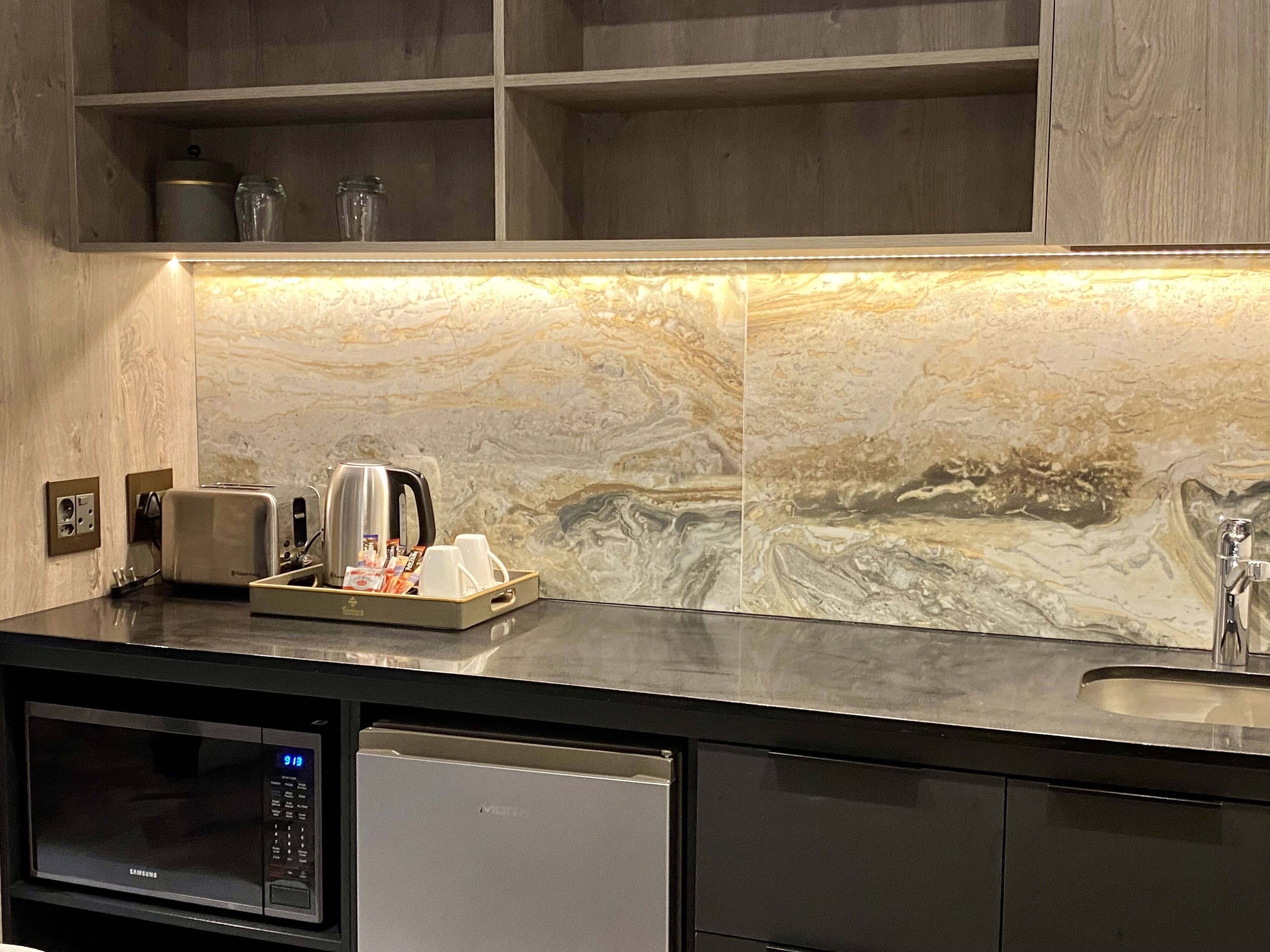 Una cocina moderna con microondas, tostadora y cafetera sobre la encimera.