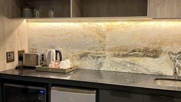 Una cocina moderna con microondas, tostadora y cafetera sobre la encimera.
