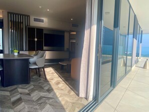 A modern interior with a herringbone floor, a bar area, seating, and a large window offering a view. - Coastlands Skye Hotel (Umhlanga)