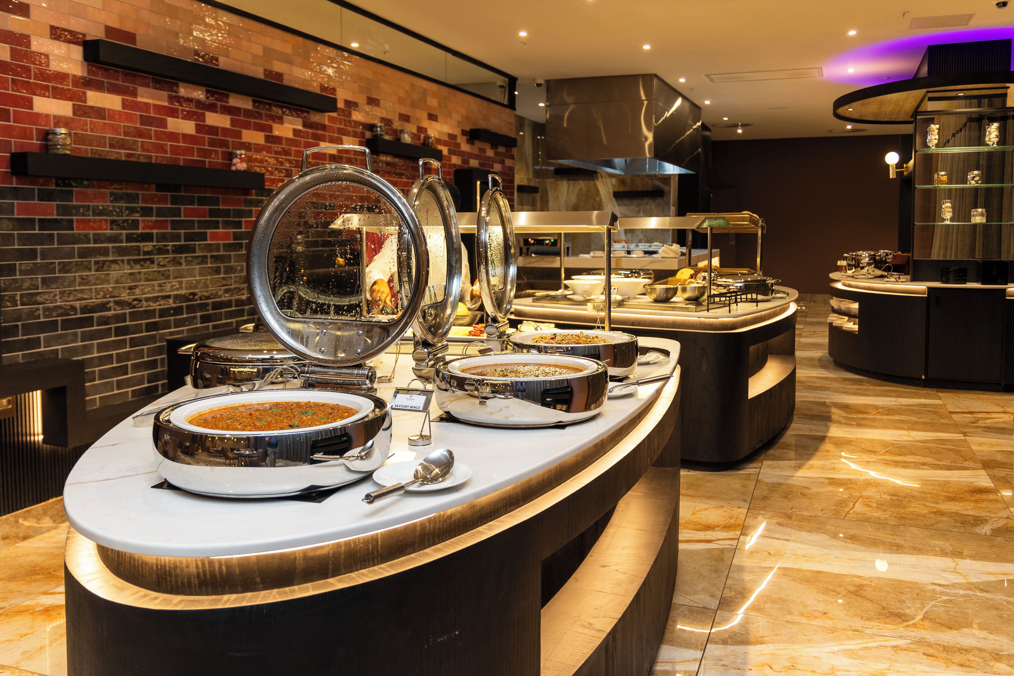 A buffet setup with multiple serving stations, each with a large bowl and a spoon.