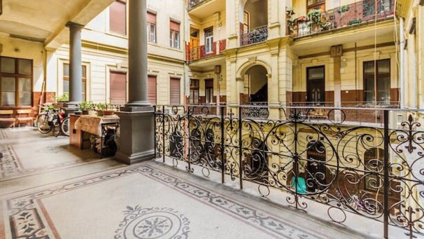 A multi-story building with balconies, a covered courtyard, and a decorative wrought iron railing. - W17Cozy in the Inner city, Cleaned by the Owner (Budapest)