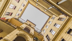 A multi-story building with a central courtyard, balconies, and a large open space in the middle. - W17Cozy in the Inner city, Cleaned by the Owner (Budapest)