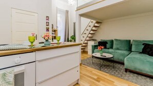 A modern apartment with a kitchen, a green sofa, and a staircase. - W17Cozy in the Inner city, Cleaned by the Owner (Budapest)