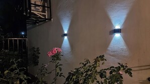 Fachada de edificio con dos luces fijadas a la pared proyectando sombras.