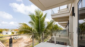 Ein Balkon mit Blick auf Palmen und eine entfernte Landschaft.