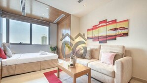 Ein modernes Wohnzimmer mit einer Couch, einem Couchtisch und einer Wand mit abstrakter Kunst.